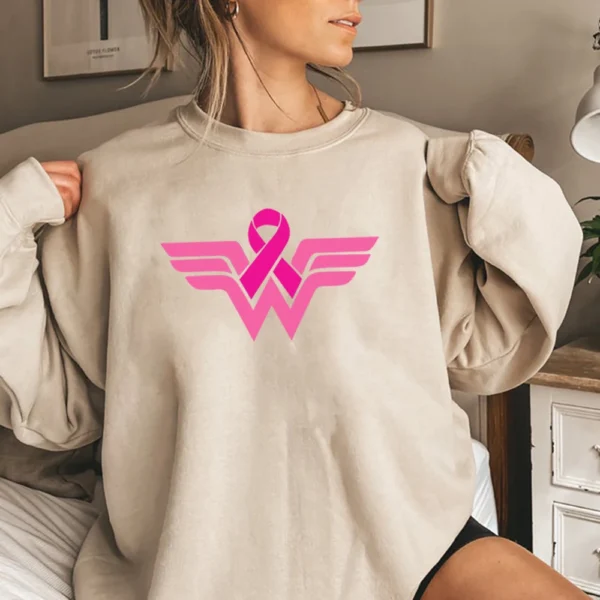 A woman sitting on a bed wearing a Superhero Sweatshirt.