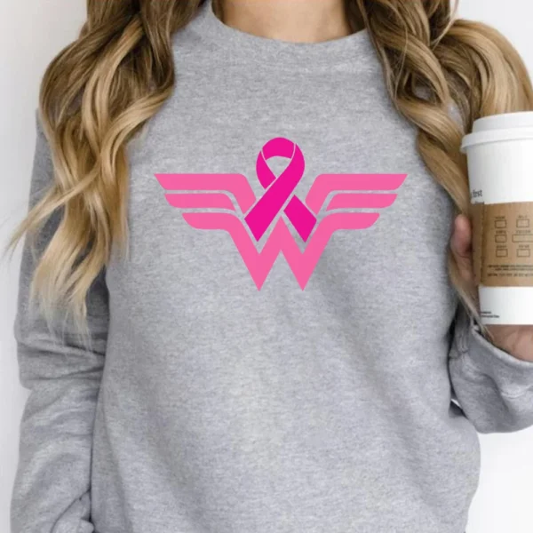 A woman wearing a Superhero Sweatshirt with a pink breast cancer ribbon.