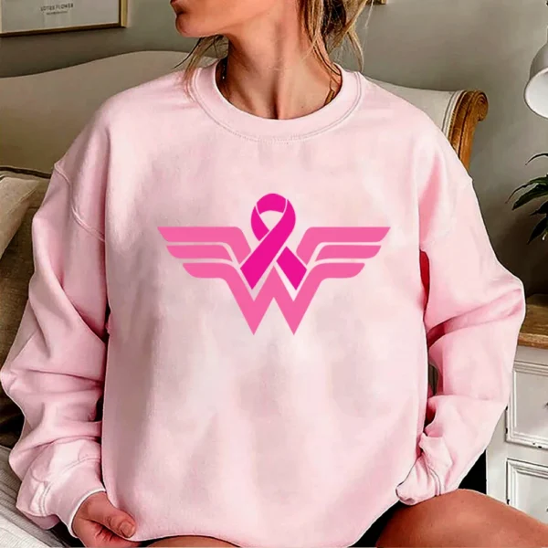 A woman wearing a Superhero Sweatshirt with a breast cancer symbol.