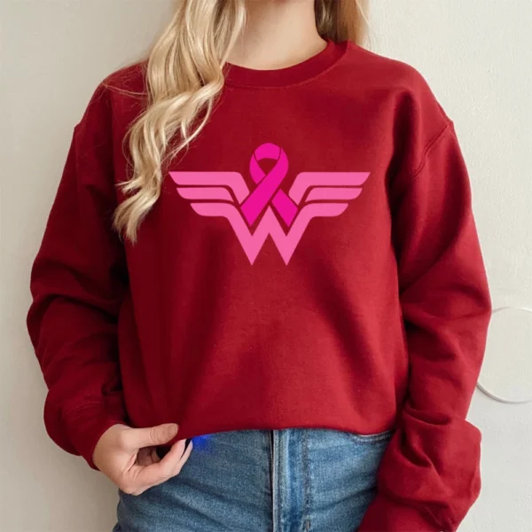 A woman wearing a Superhero Sweatshirt with a pink ribbon on it.