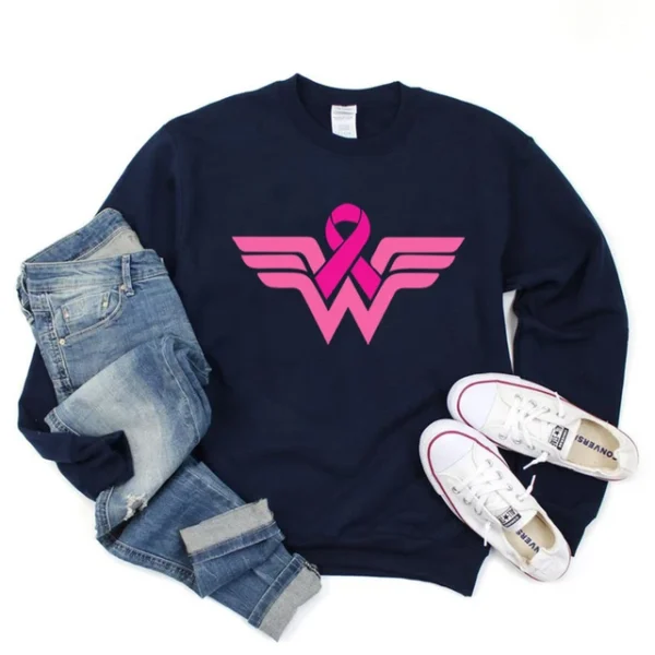 A blue superhero sweatshirt with pink logo and jeans and white shoes.