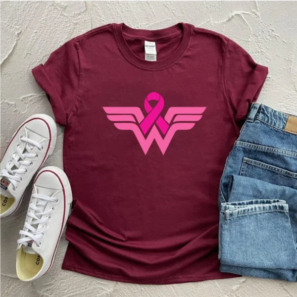 A Superhero T-shirt with pink logo and jeans and white shoes.