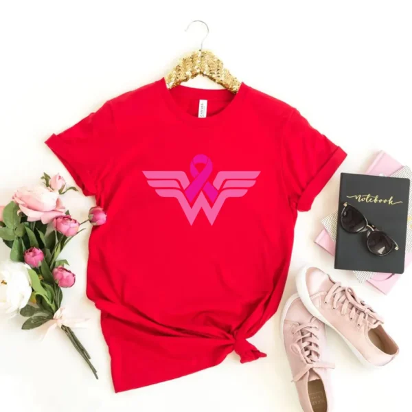 A superhero T-shirt with a logo on it and flowers and a book.